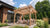  Five adults relax beneath a cedar Yardistry pergola on a landscaped backyard patio.